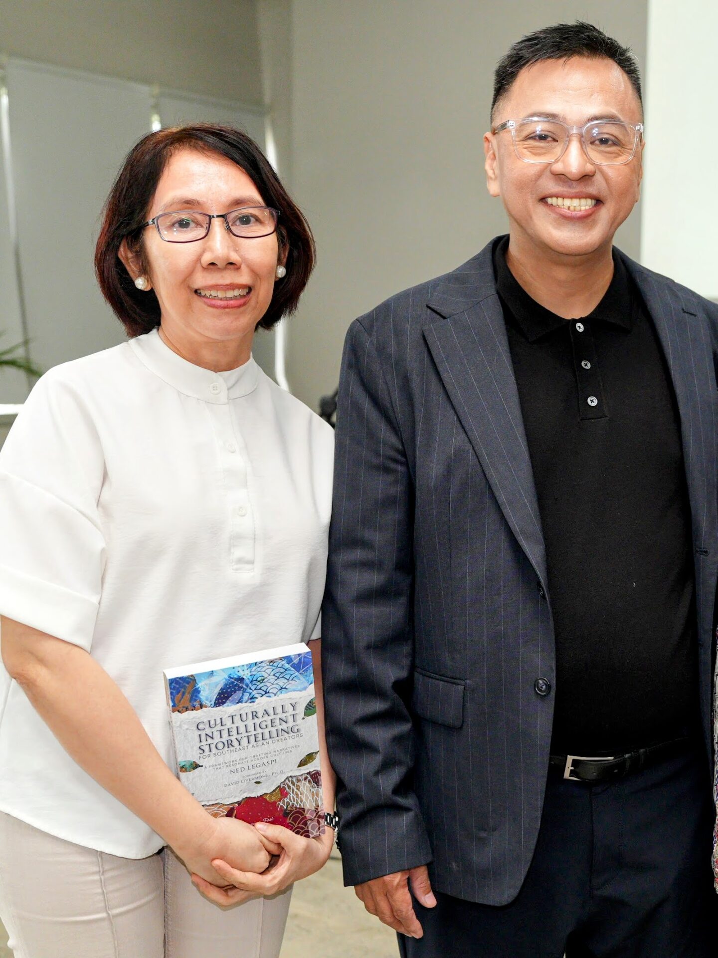 Aileen Carreon with a copy of Culturally Intelligent Storytelling for Southeast Asian Creators