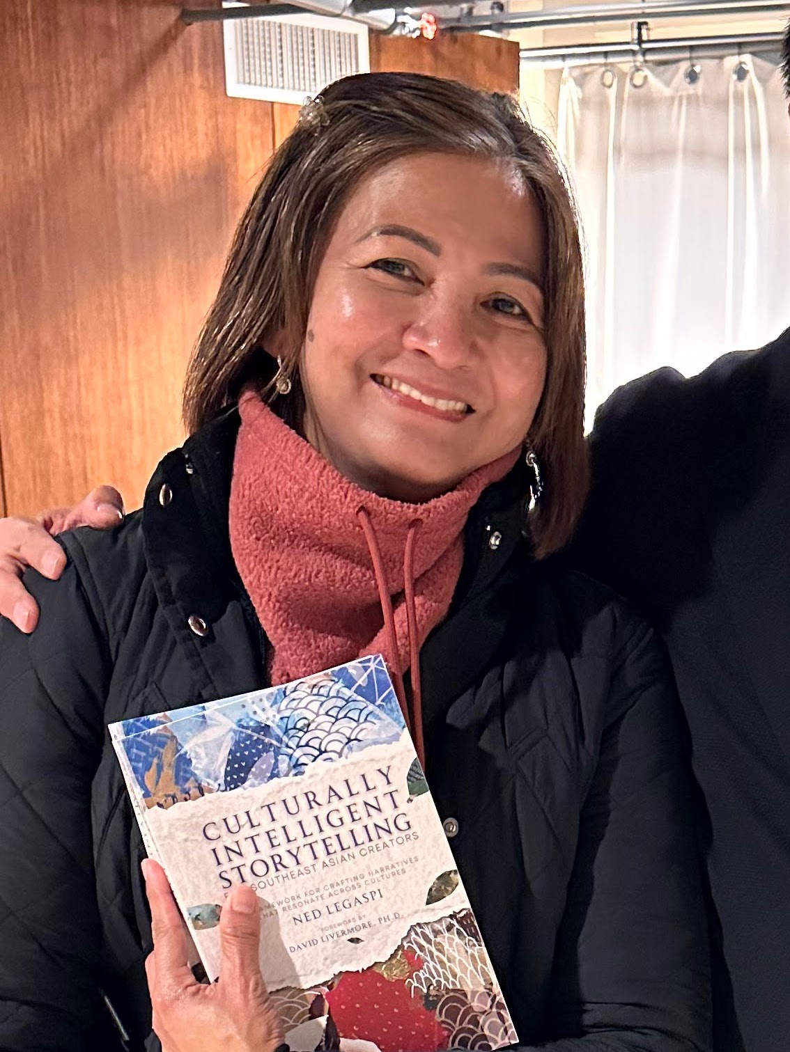 Alma Magsombol with a copy of Culturally Intelligent Storytelling for Southeast Asian Creators
