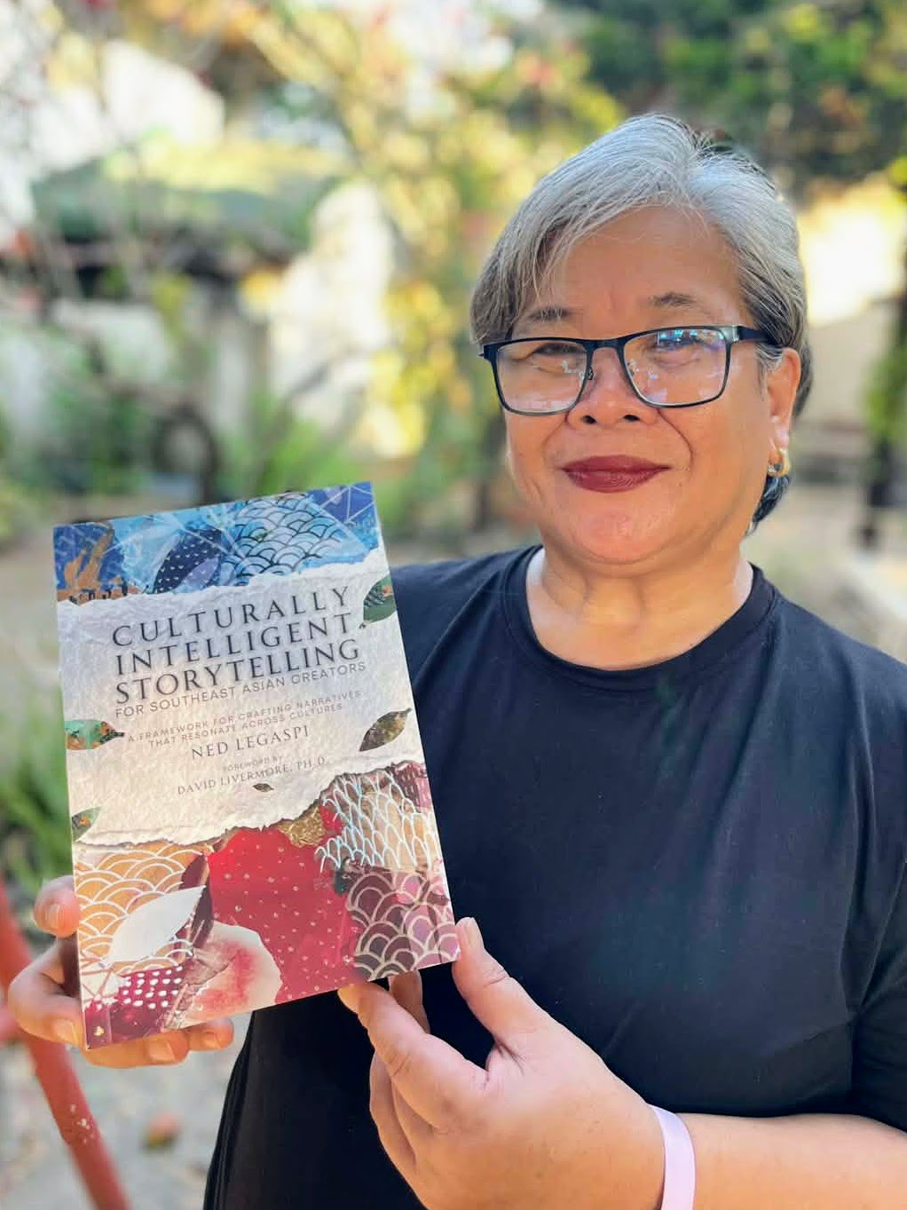 Bernadette Suyao holding a copy of Culturally Intelligent Storytelling for Southeast Asian Creators