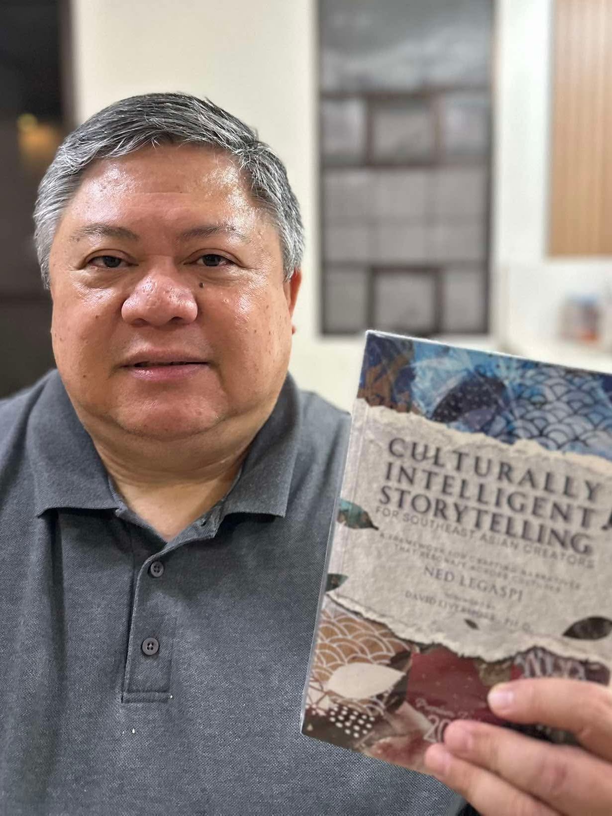 Biboy Clemente with a copy of Culturally Intelligent Storytelling for Southeast Asian Creators