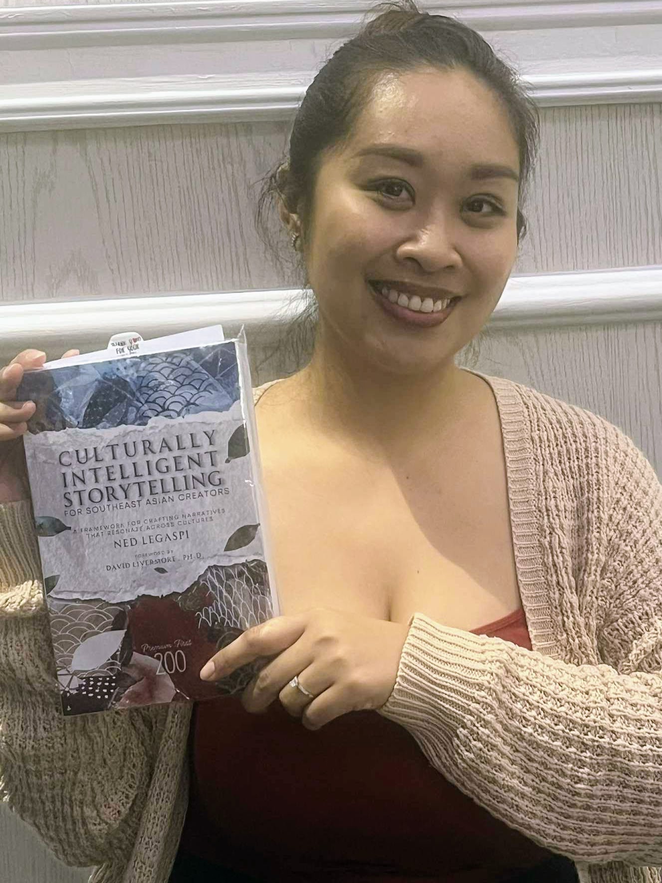 Chessika Sy with a copy of Culturally Intelligent Storytelling for Southeast Asian Creators