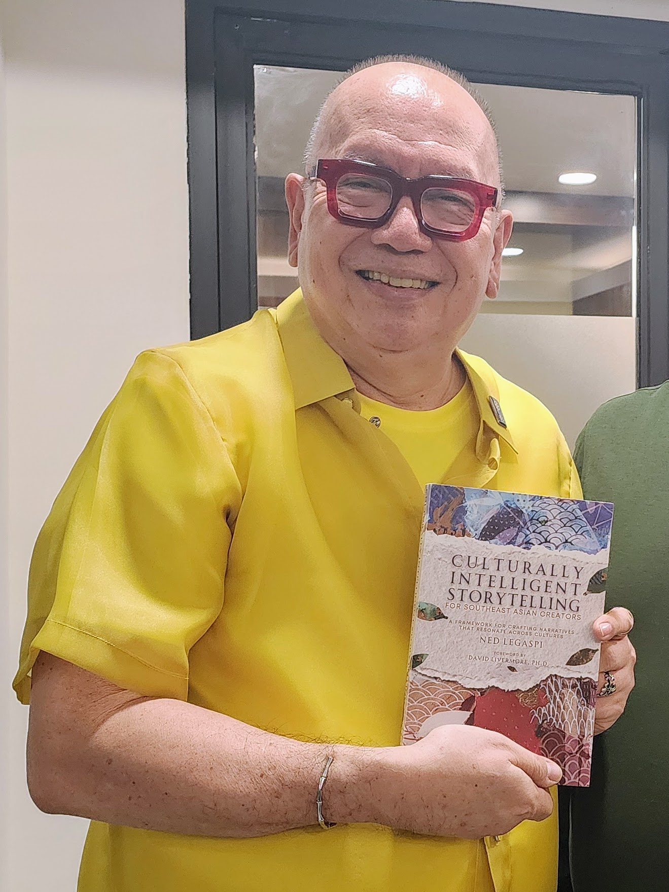 Film Development Council of the Philippines Chairman and CEO Jose Joey Javier Reyes and author Ned Legaspi holding a copy of Culturally Intelligent Storytelling for Southeast Asian Creators