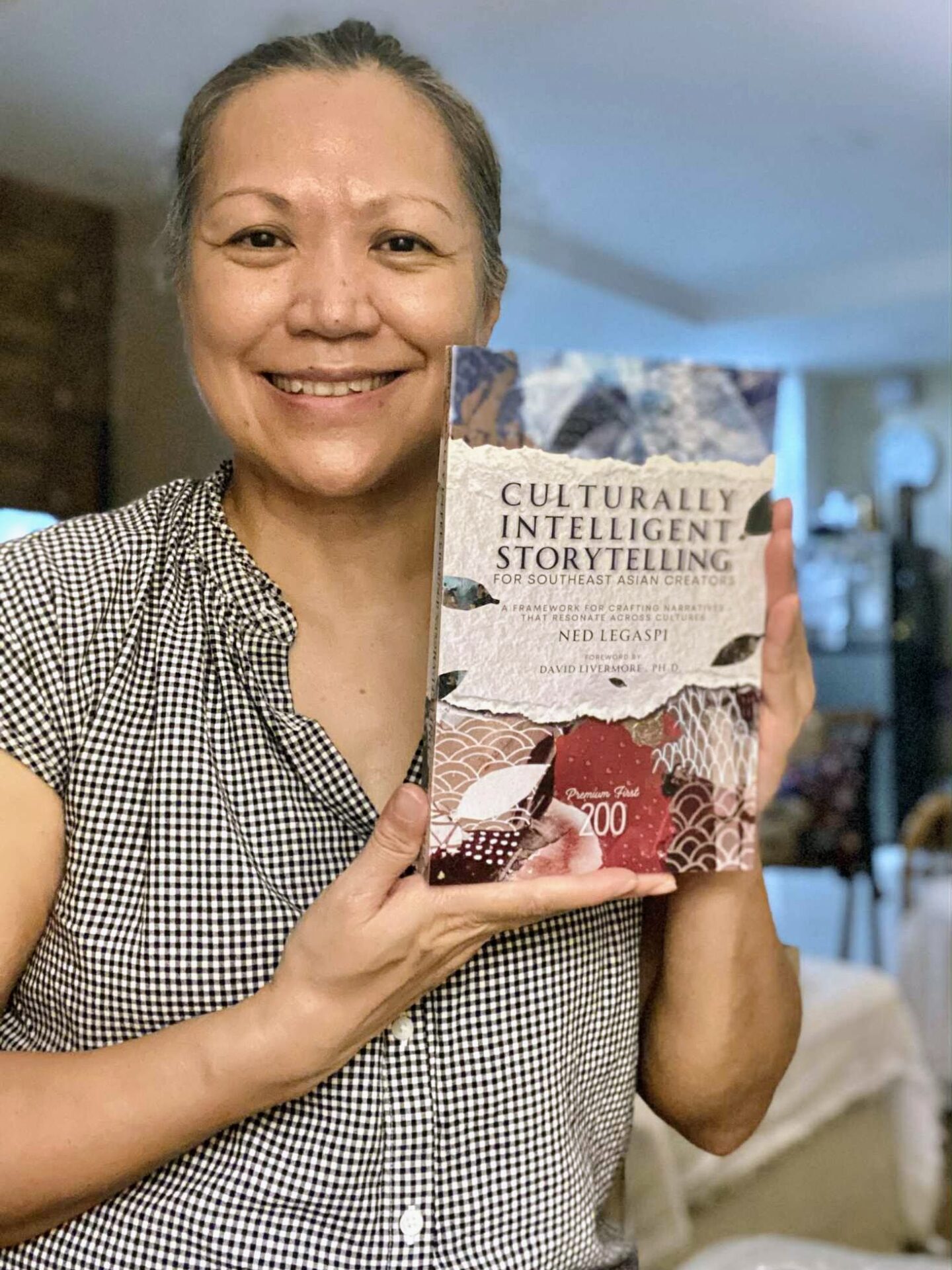 Donna Lampano with a copy of Culturally Intelligent Storytelling for Southeast Asian Creators