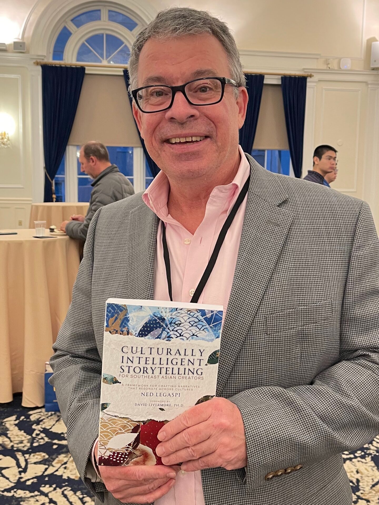 Dr. James A. Cook with a copy of Culturally Intelligent Storytelling for Southeast Asian Creators