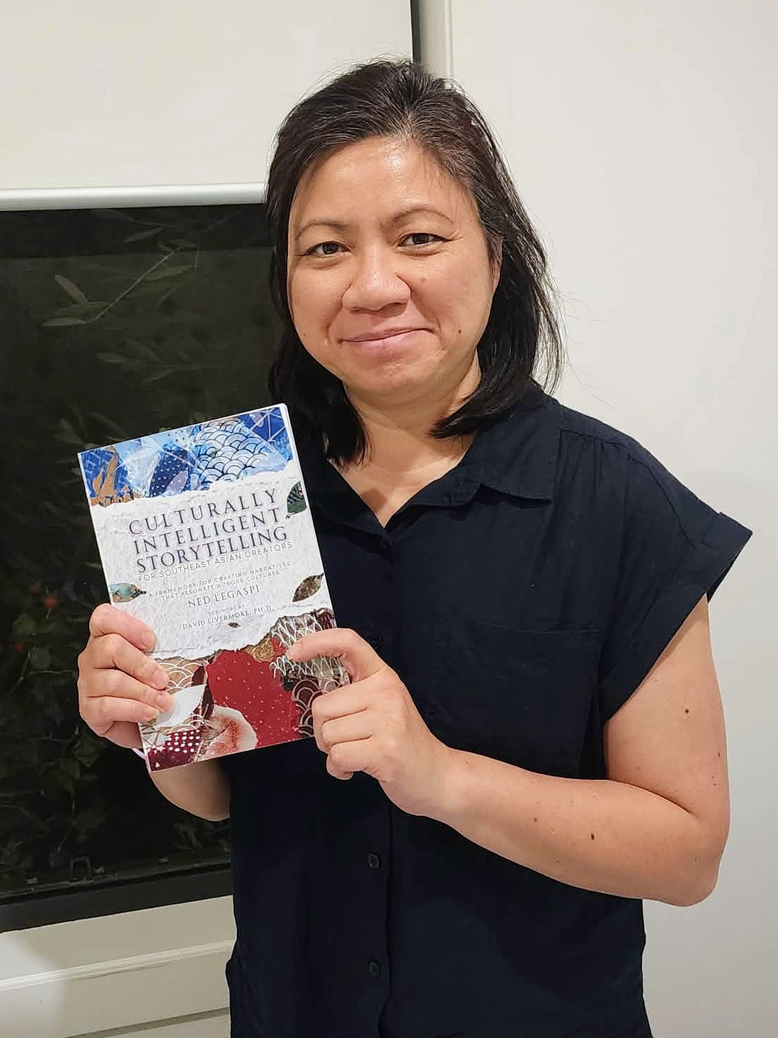 Jasmina Ong with a copy of Culturally Intelligent Storytelling for Southeast Asian Creators in Canberra, Australia