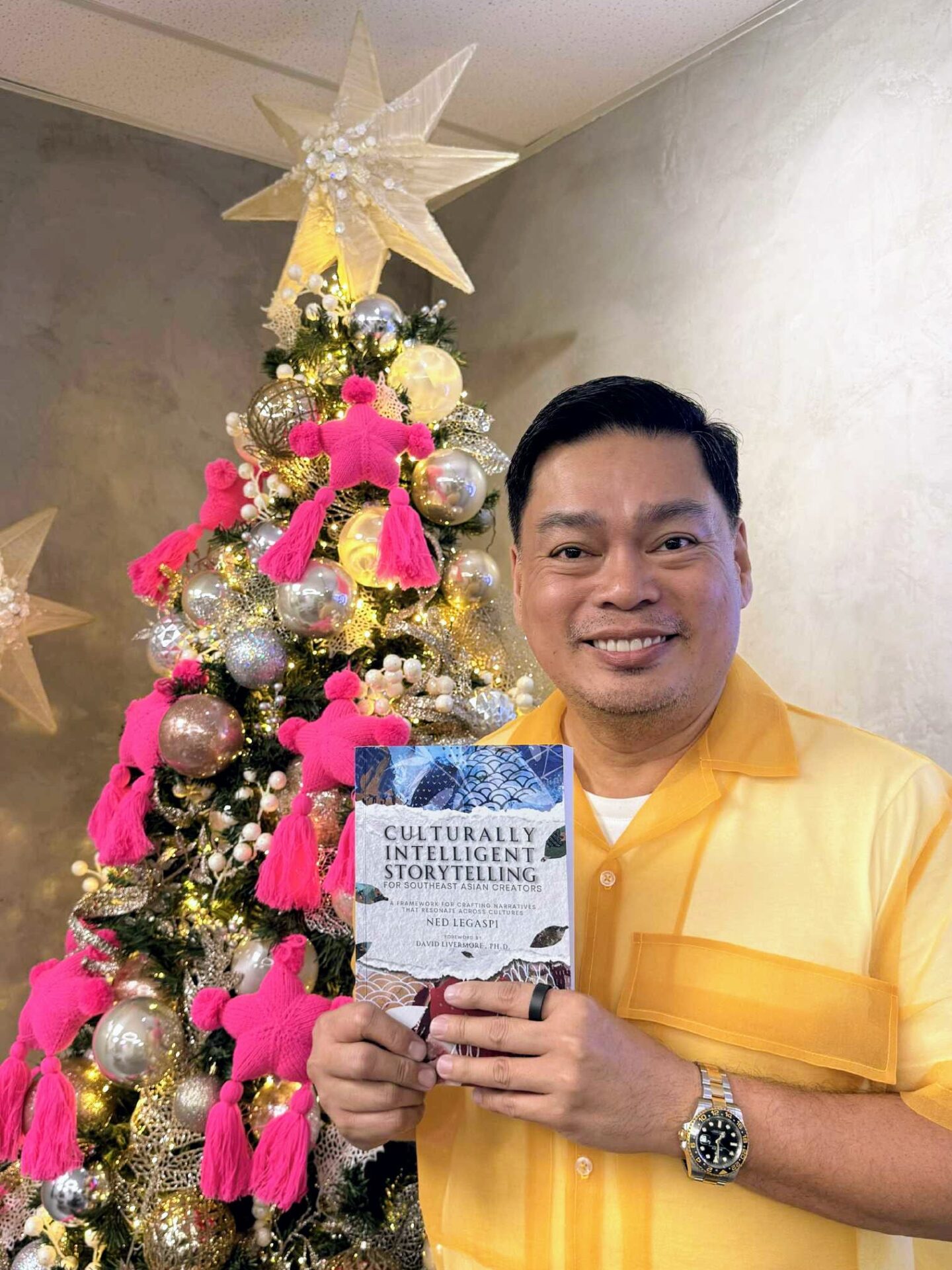 JC Catibog with a copy of Culturally Intelligent Storytelling for Southeast Asian Creators
