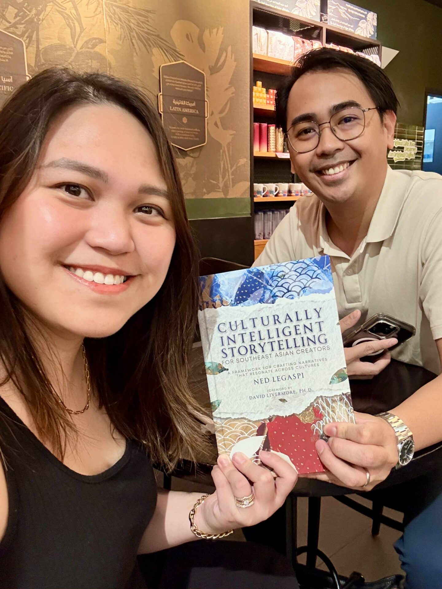 John Lawrence and Andrea Millan with a copy of Culturally Intelligent Storytelling for Southeast Asian Creators in Dubai, United Arab Emirates