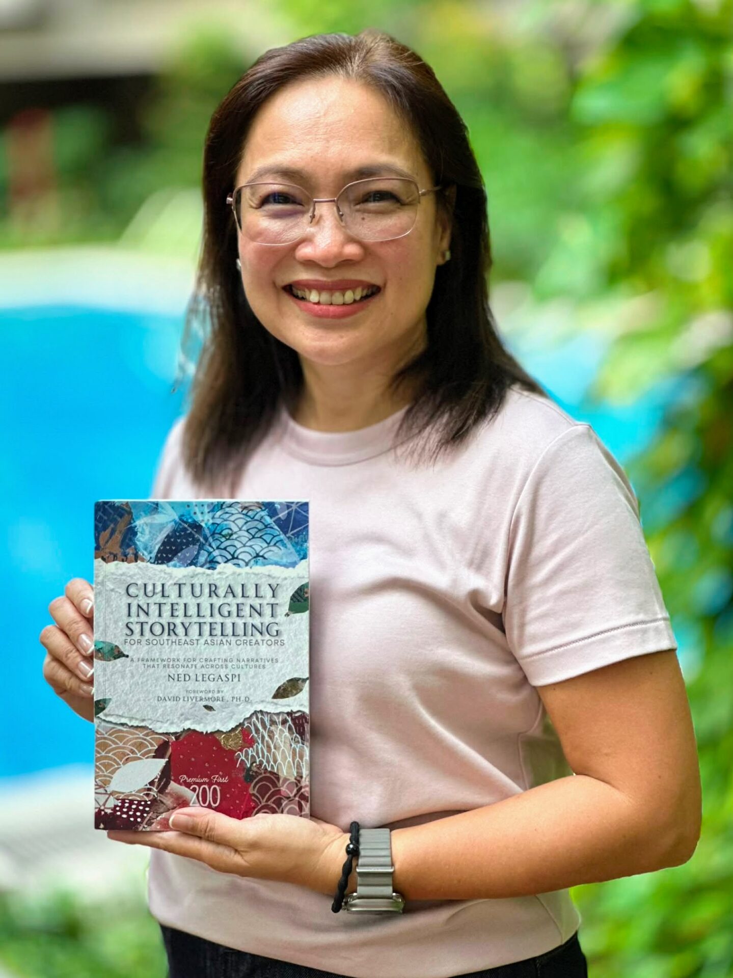 Jules Terrado-Acosta with a copy of Culturally Intelligent Storytelling for Southeast Asian Creators
