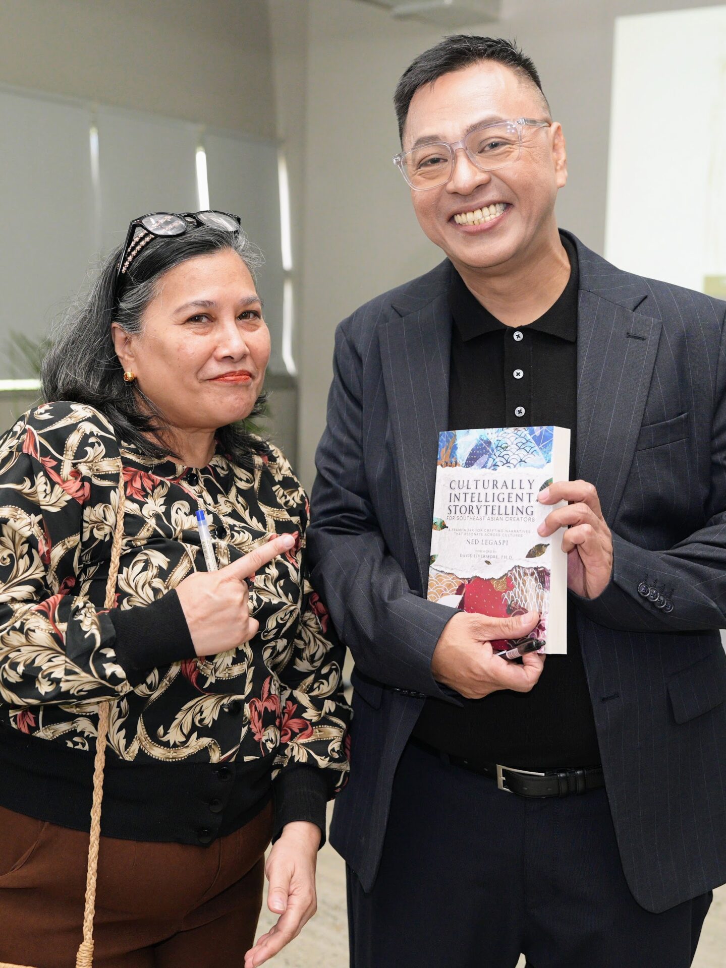 Marielle Gaceta-Catbagan with a copy of Culturally Intelligent Storytelling for Southeast Asian Creators
