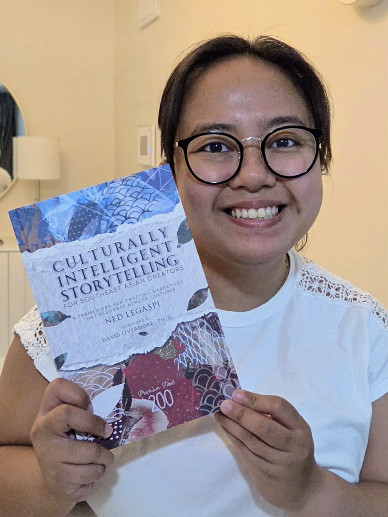 Mia Fadriquela with a copy of Culturally Intelligent Storytelling for Southeast Asian Creators