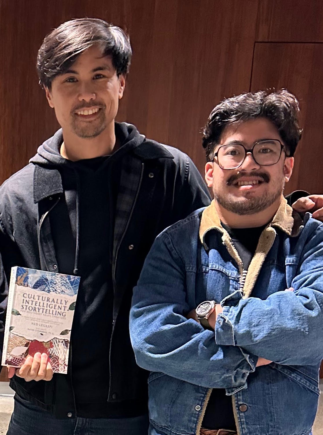 Miguel Carrion and Jeremiah Ysip with a copy of Culturally Intelligent Storytelling for Southeast Asian Creators