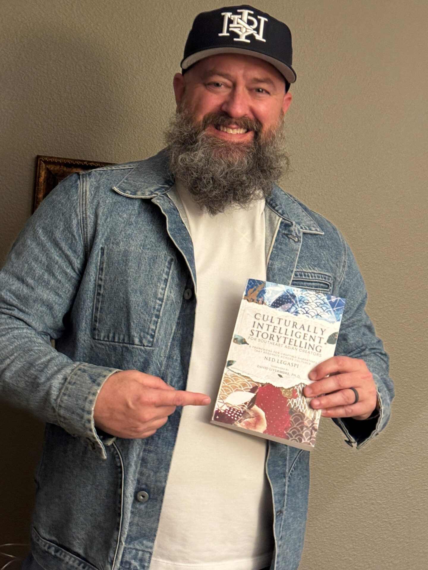 Mike Newton with a copy of Culturally Intelligent Storytelling for Southeast Asian Creators in Greater Indianapolis, Indiana