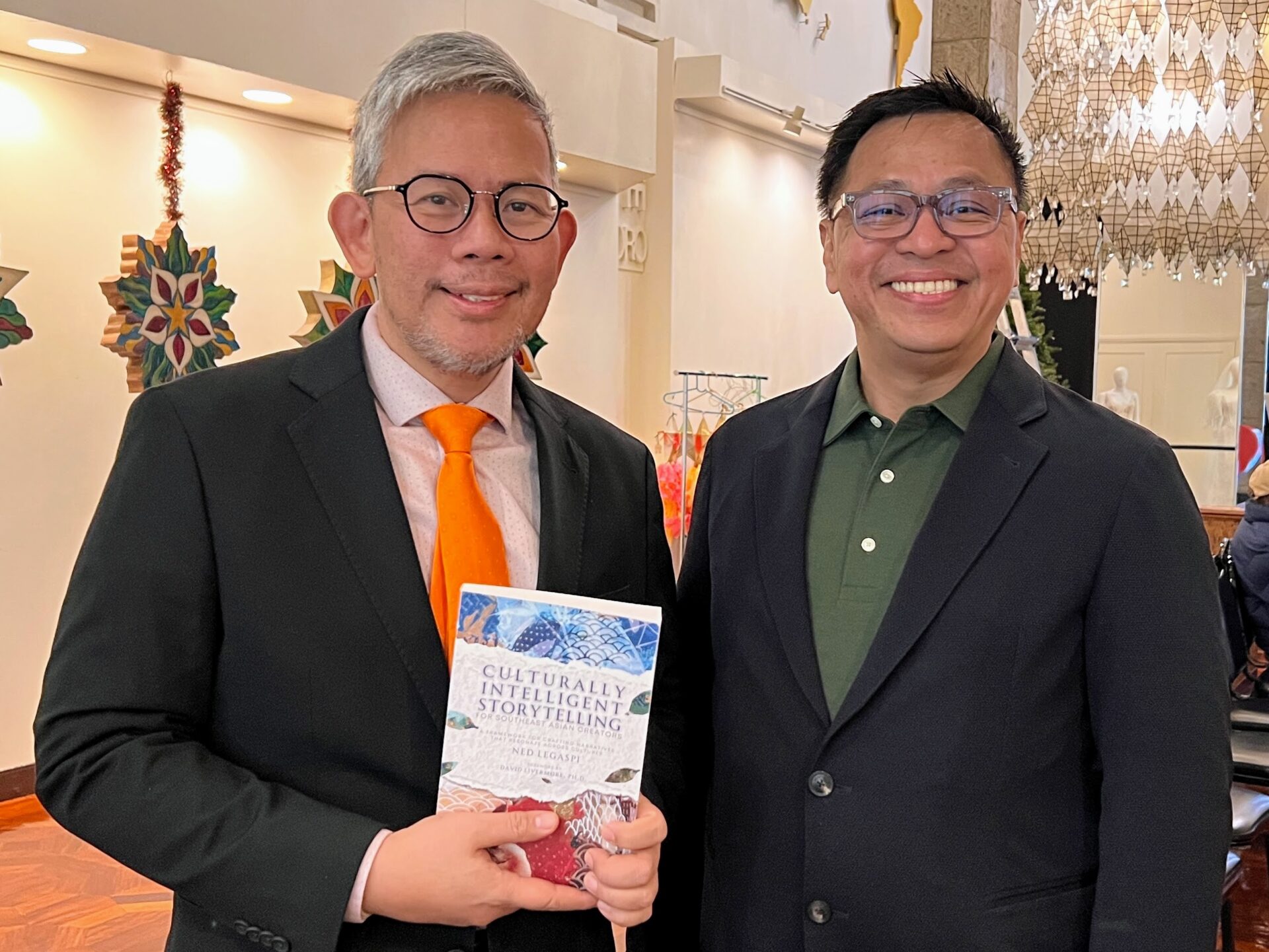Ned Legaspi with Adrian Elmer S. Cruz in New York holding a copy of Culturally Intelligent Storytelling for Southeast Asian Creators
