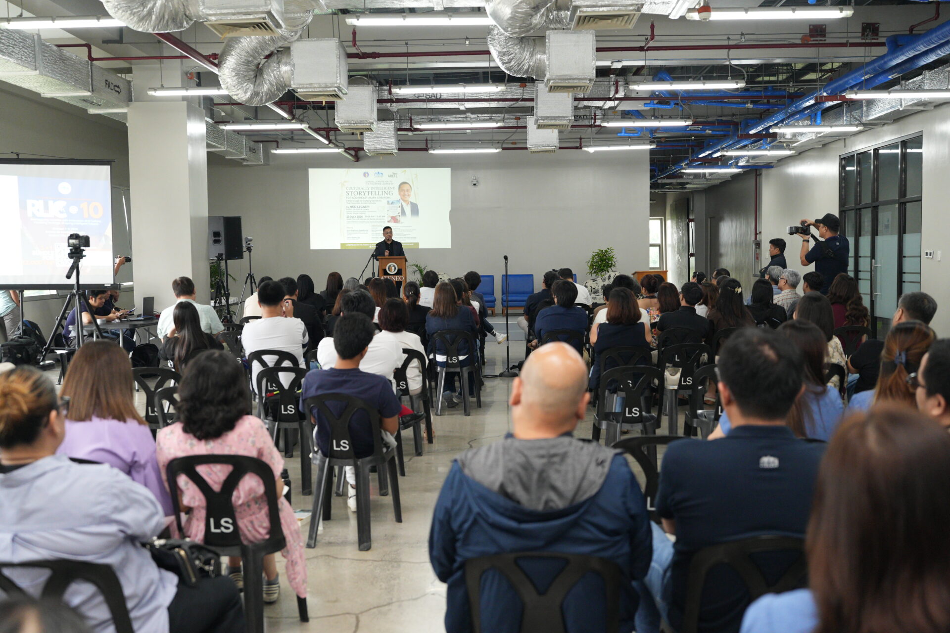Ned Legaspi speaking before a large audience at the Ateneo Philippine book launch