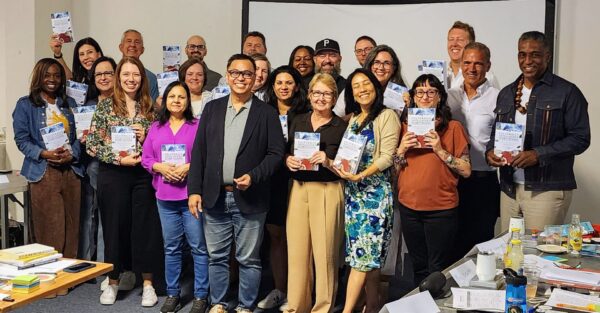 Ned Legaspi with members of the CQ Fellows community holding copies of Culturally Intelligent Storytelling during its international launch in Santa Monica, California