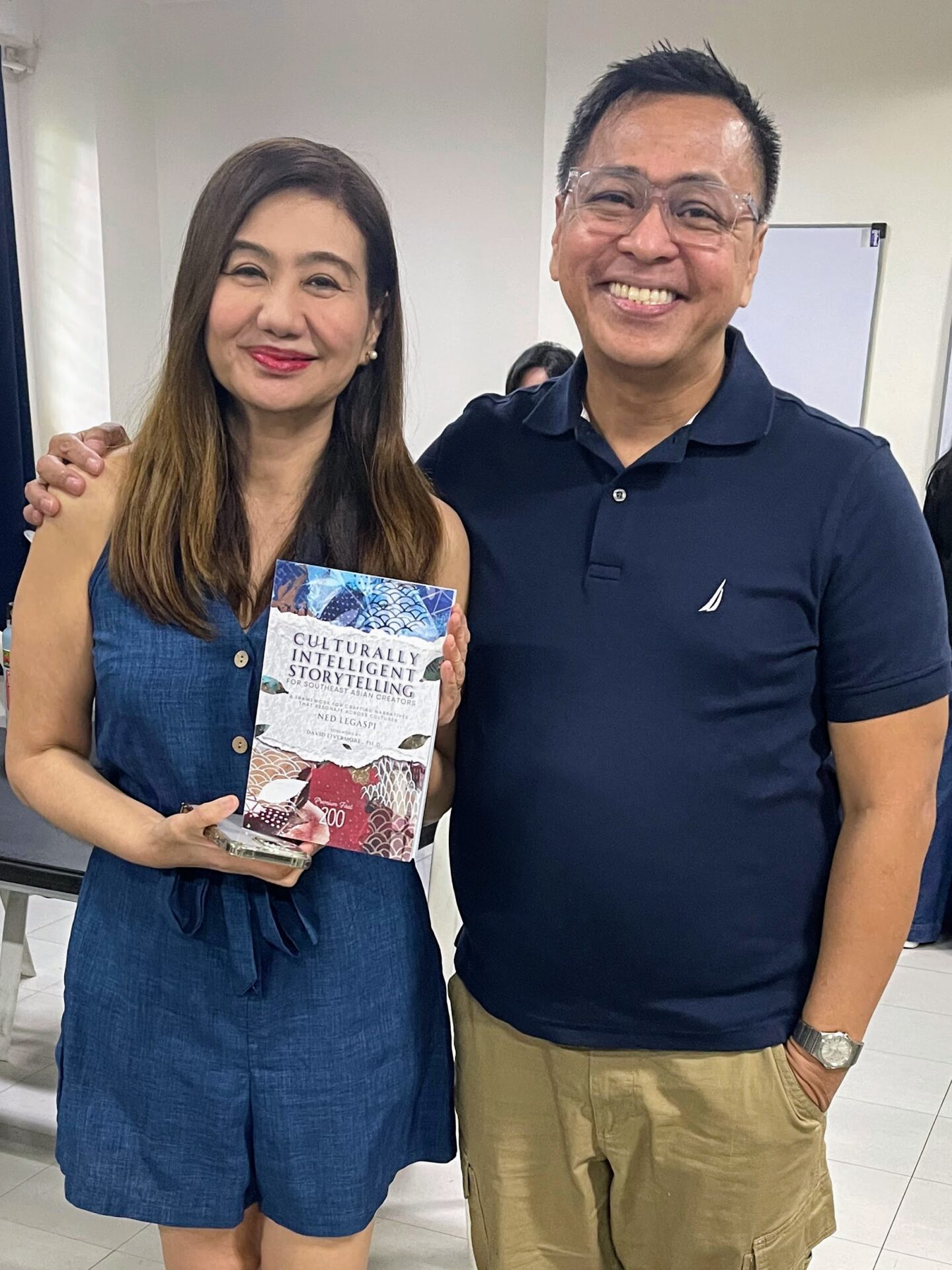 Tina Manzano-Barbin with a copy of Culturally Intelligent Storytelling for Southeast Asian Creators