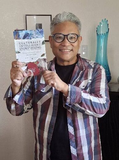Pon Angara with a copy of Culturally Intelligent Storytelling for Southeast Asian Creators