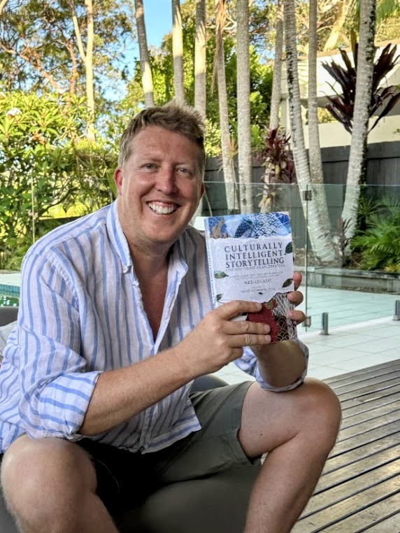 Tim Barrett holding a copy of Culturally Intelligent Storytelling for Southeast Asian Creators